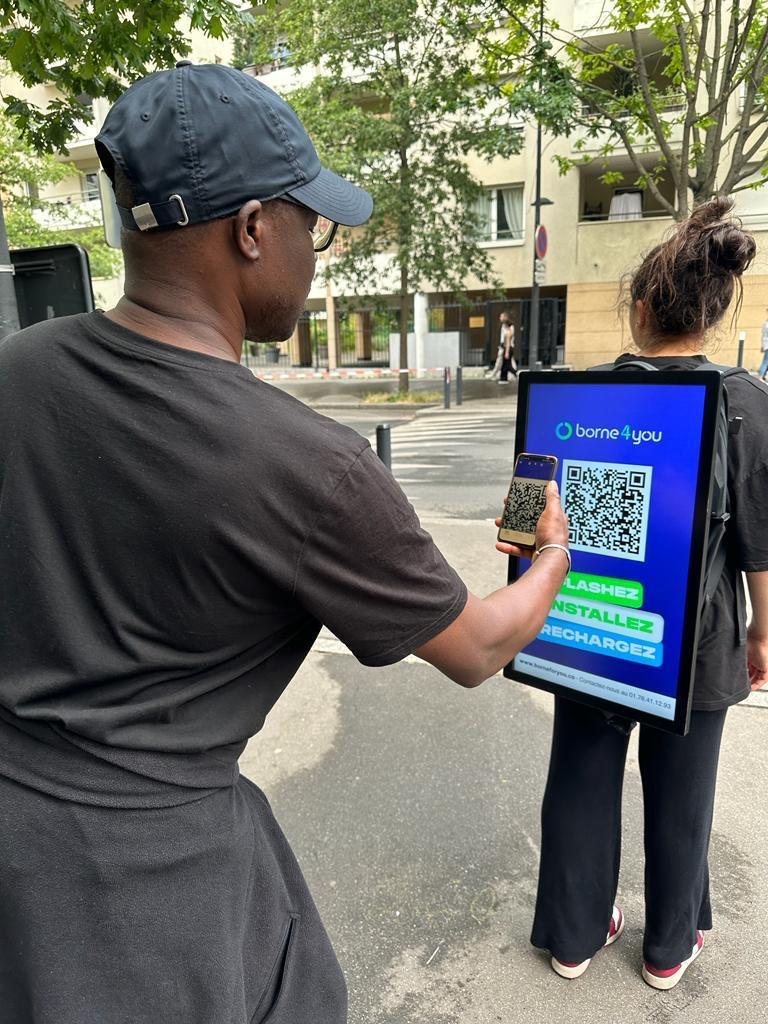 A passer-by scanning the QR code on a promoter's backpack screen